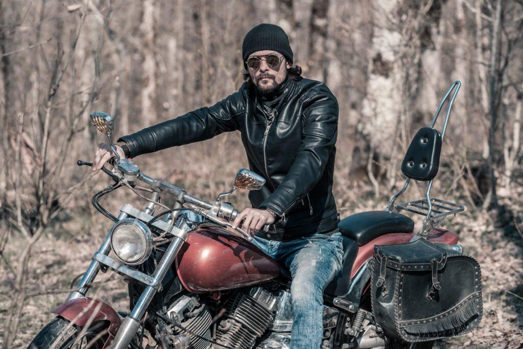 Biker mit schwarzer Lederjacke auf rotem Motorrad | Motorradbekleidung von Held