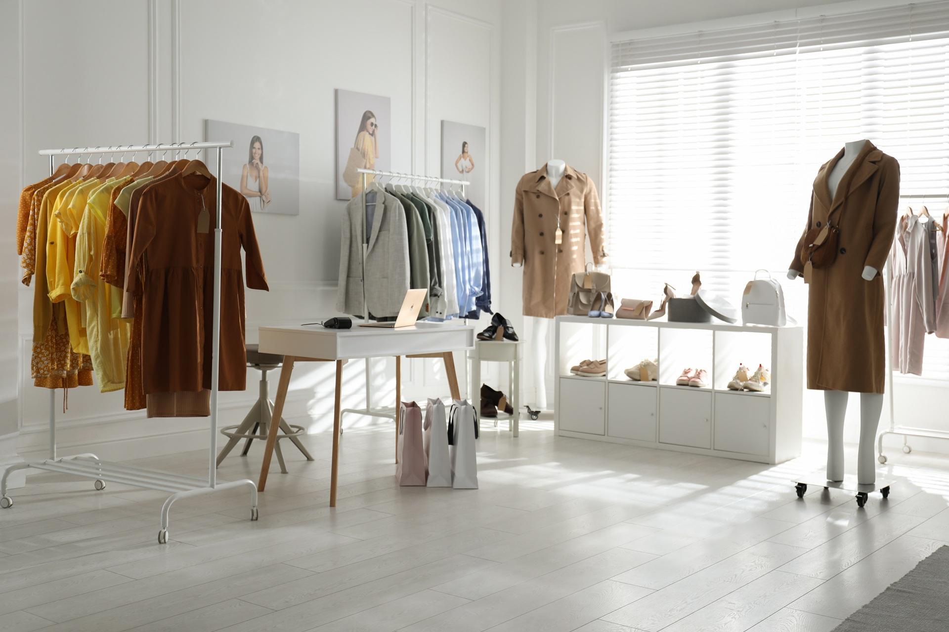 Heller Showroom mit Kleidung und Accessoires | Garderobenständer