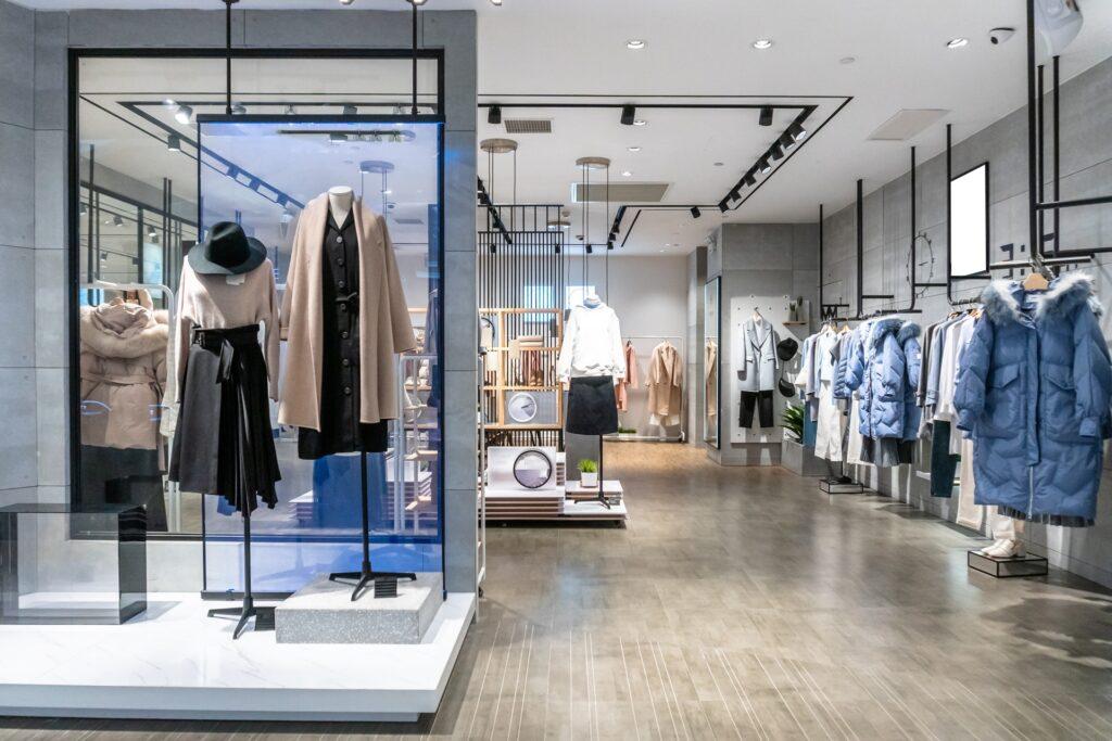 Elegante Boutique mit Auslage und Kleidung | Garderobenständer